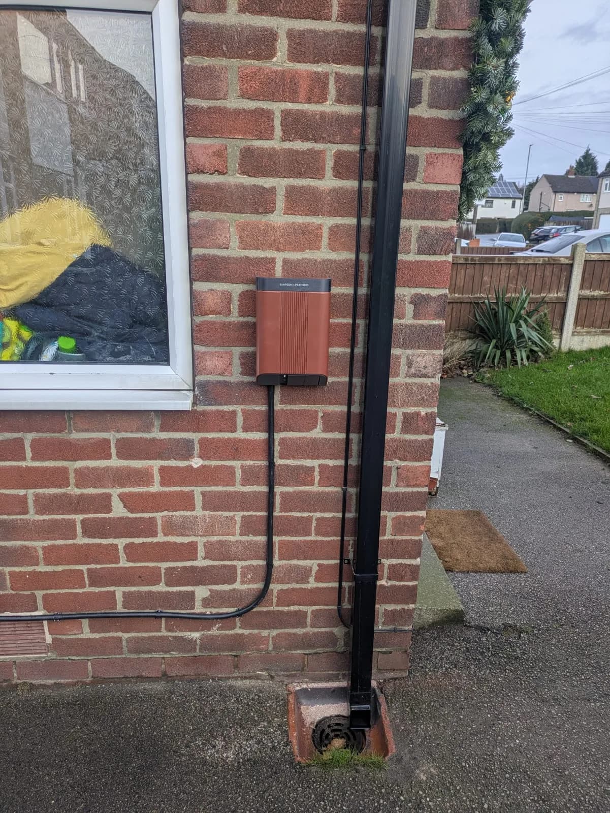 EV charger professionally installed on exterior brick wall